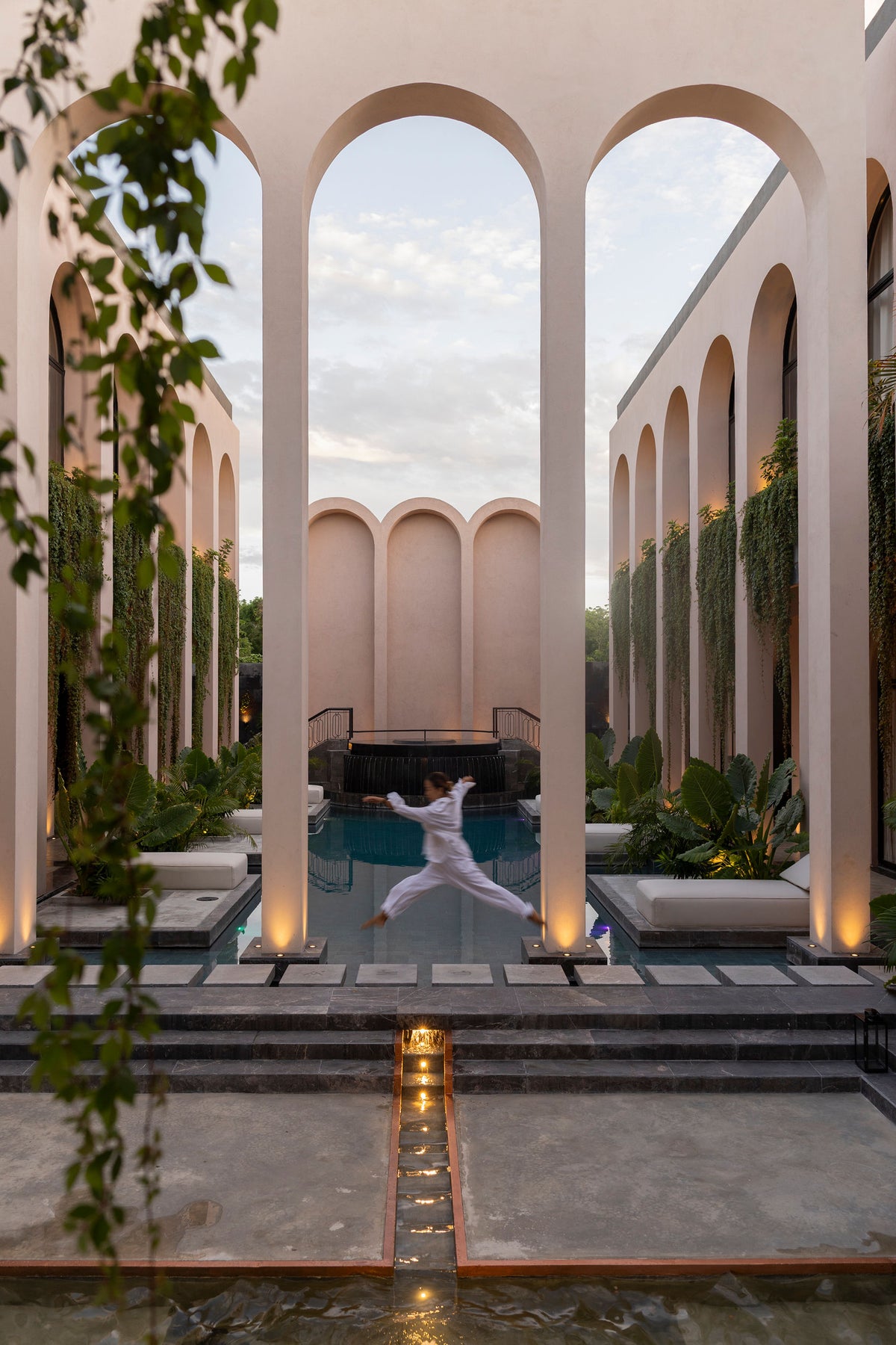 The arcade at dusk, the reflecting pool running the length of the house
